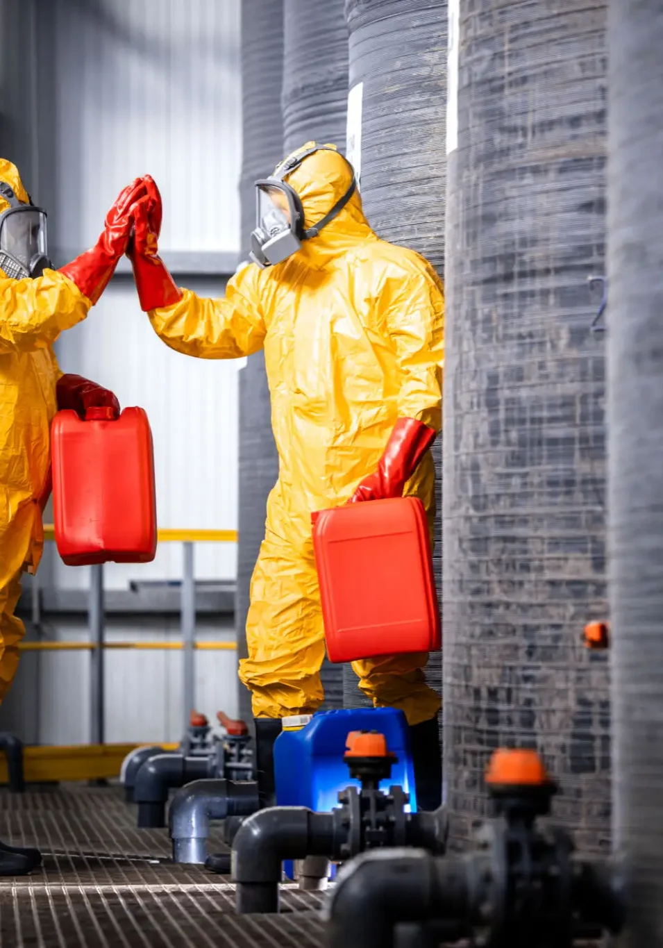 Two workers in hazmat suits giving a high five.